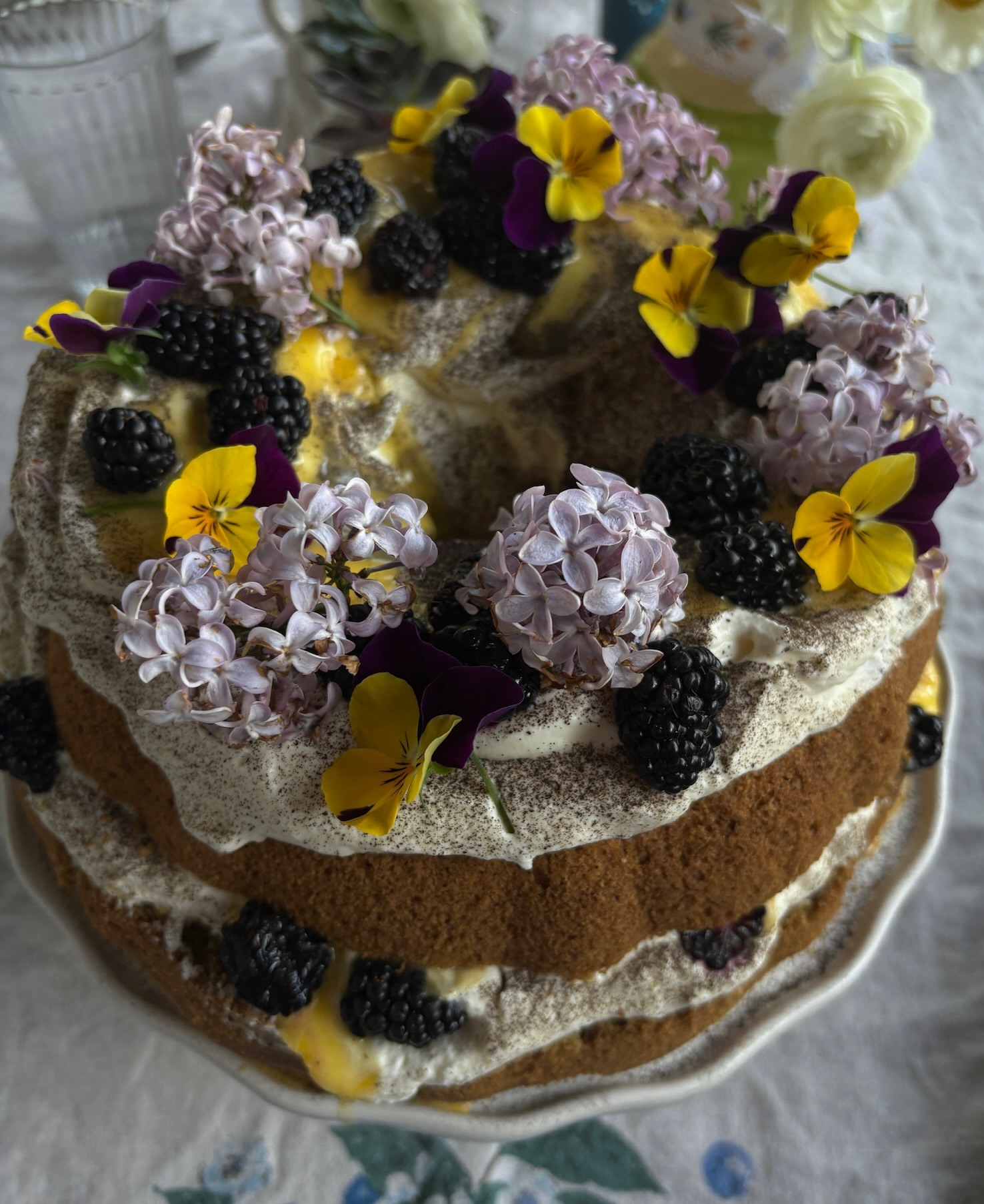 Naked layered cake with lilacs and pansies, close-up